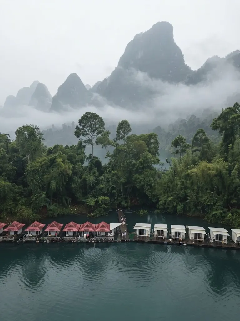 Raft houses beneath mist-covered karst peaks