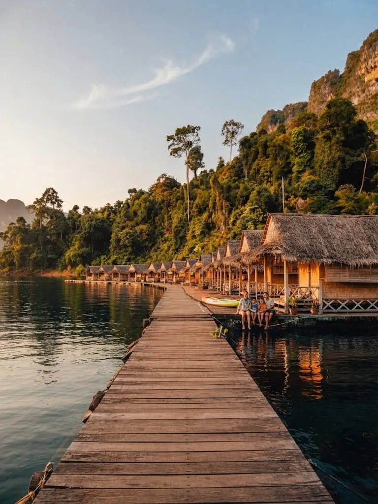 Wooden walkway leading to thatched floating bungalows on the lake